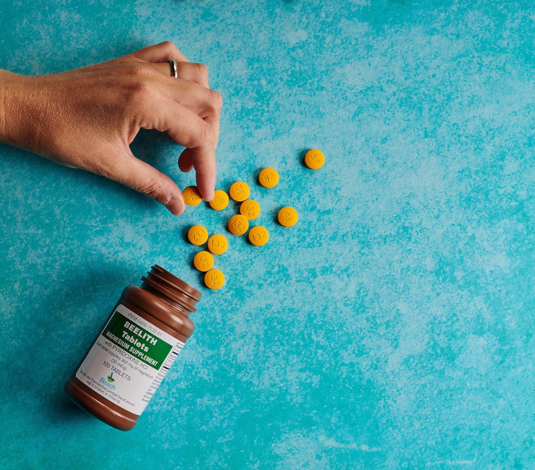 a person is picking up some pills from a bottle
