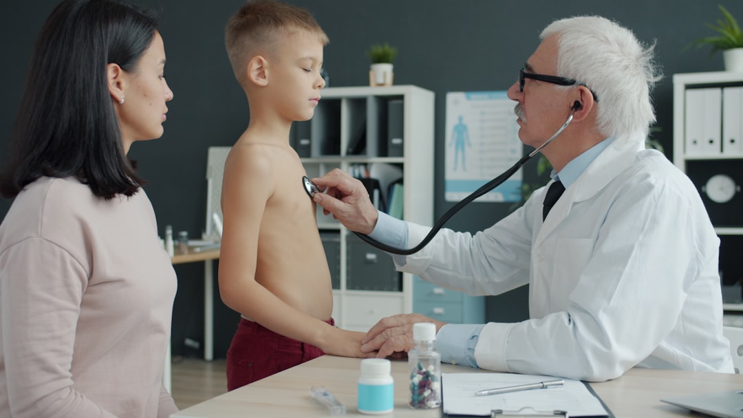 Internal Medicine vs Primary Care: What Is the Difference? 7 Doctor examines boy's chest with stethoscope while mother watches.