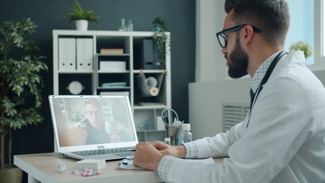 MDLIVE Review: Telehealth Services, Pricing, and Insurance 3 Doctor consulting patient via video call on laptop.