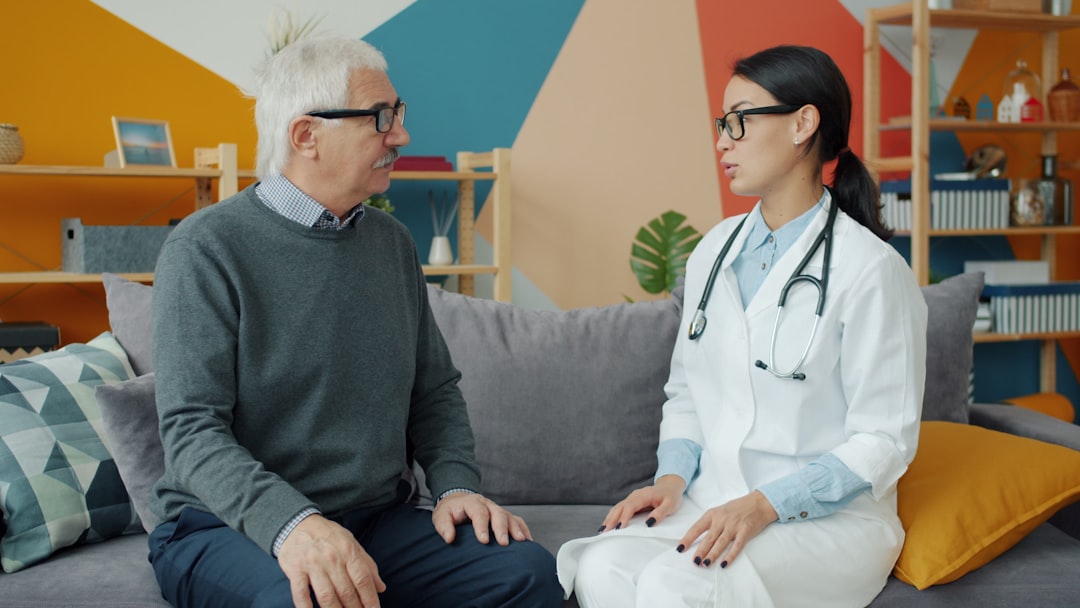 Medicaid vs Medicare: Key Differences Explained 8 Doctor talks with an elderly patient on a couch.